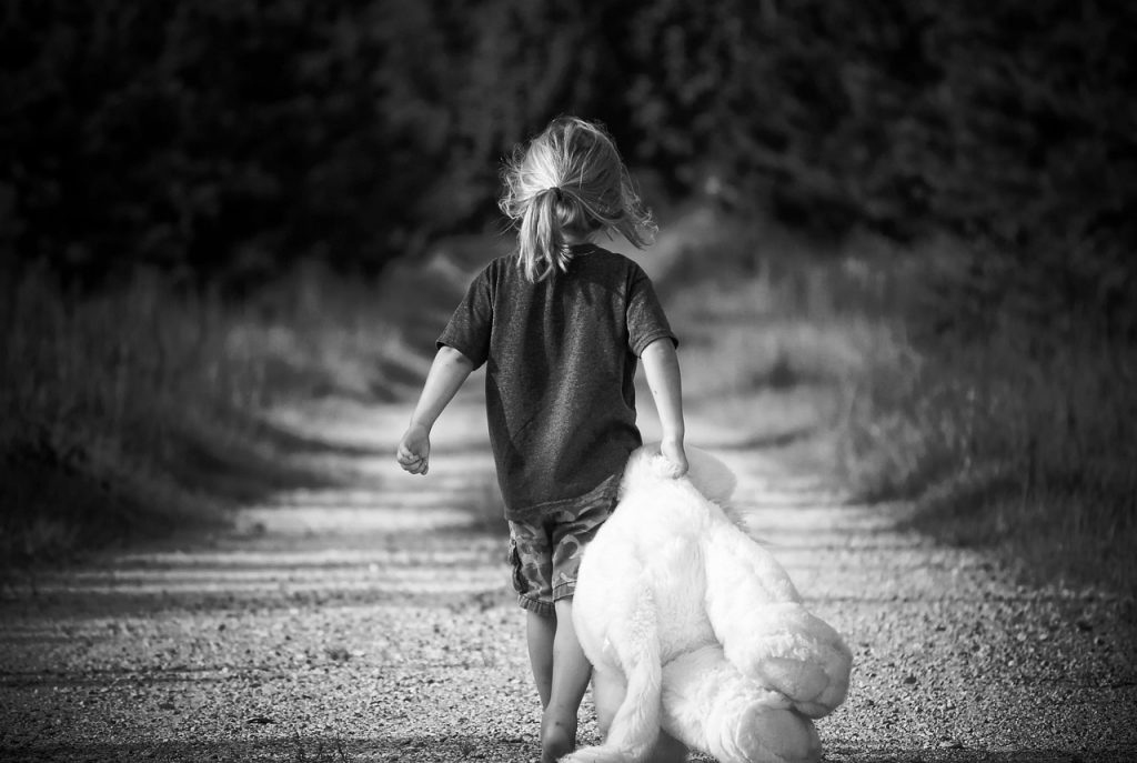 Uma imagem com uma criança e seu urso de pelúcia